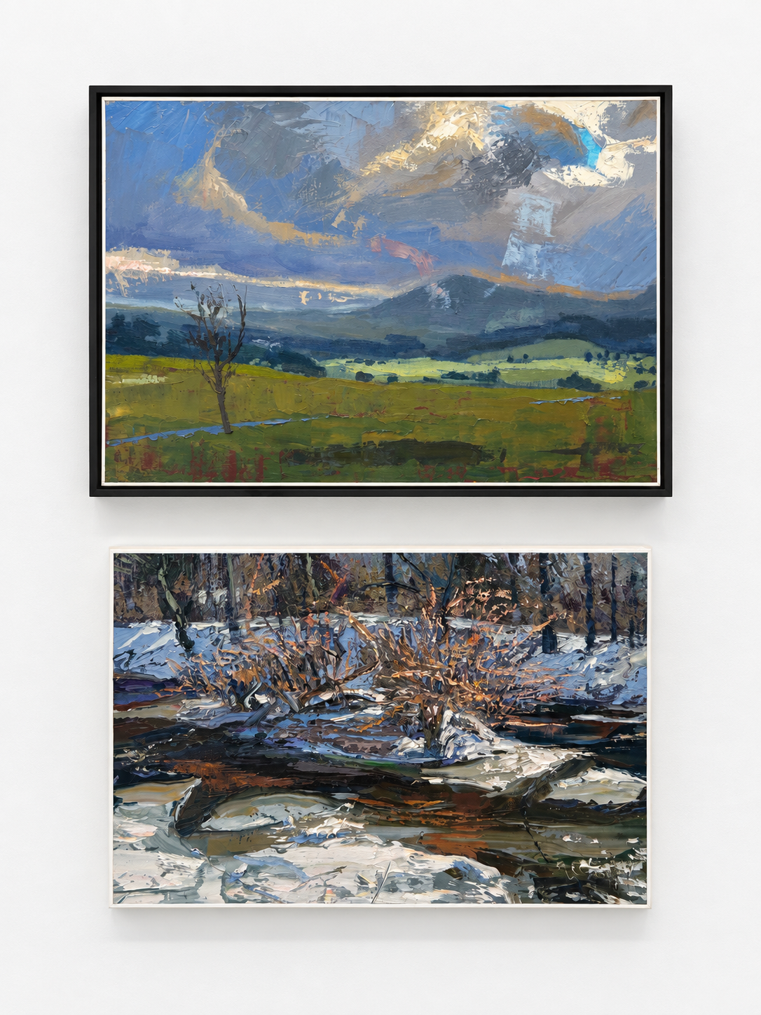 Two landscape paintings displayed on the gallery wall